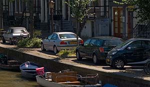 Hyrbil parkerad nära kanal i Amsterdam